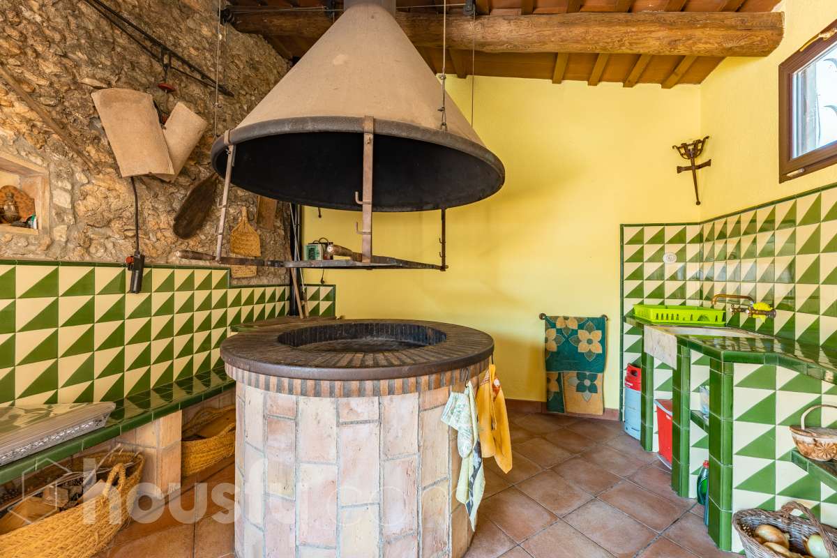 Housfy vende masía histórica de finales del S.XIX – El corazón del Penedès Descubra esta excepcional masía de piedra, un oasis de tranquilidad y autenticidad restaurado minuciosamente en 2010. Con una superficie construida de 351 m² sobre una extensa parcela de 8.502 m², esta propiedad combina a la perfección la tradición arquitectónica catalana con el máximo confort moderno. Lo que hace única a esta propiedad: Arquitectura y carácter: Restauración fiel que preserva elementos originales: vigas de madera de melis, techos de "volta catalana", suelos de mosaico antiguo y carpintería tradicional. Un viaje en el tiempo sin renunciar a las comodidades actuales. Entorno privilegiado: Ubicada en el corazón vinícola del Penedès, a tan solo 50 km de Barcelona y el aeropuerto, y a 20 km de Sitges. Disfrute de un entorno natural rodeado de viñedos, perfecto para actividades al aire libre como senderismo o rutas ecuestres. Zona exterior diseñada para disfrutar: Un espacio exterior con porches de columnas milenarias, piscina y una completa zona de barbacoa/horno de leña tradicional. Incluye una zona de sombra natural bajo moreras centenarias, huerto privado, frutales y un espacio polivalente de 3.700 m² apto para instalaciones hípicas. Sostenibilidad y equipamiento: La casa cuenta con sistema de calefacción geotérmica de alta eficiencia, pozos propios (caudal garantizado de 9.000 l/h), depuradora ecológica y conexión a fibra óptica, garantizando un funcionamiento autónomo y eficiente. Distribución y detalles: Amplios espacios interiores, incluyendo una biblioteca, cocina rústica de 28 m² con chimenea, gran salón de reuniones con capacidad para 24 comensales y bodega. La planta superior conserva el encanto original con acceso a un desván polivalente de 90 m². Esta propiedad es ideal para quienes buscan una residencia singular, un refugio de fin de semana o una oportunidad de inversión en una de las zonas más demandadas y con mayor encanto de Cataluña. Quiere visitarla? Contacte con Housfyy agende su visita sin compromiso. Más información en: housfy.com-64