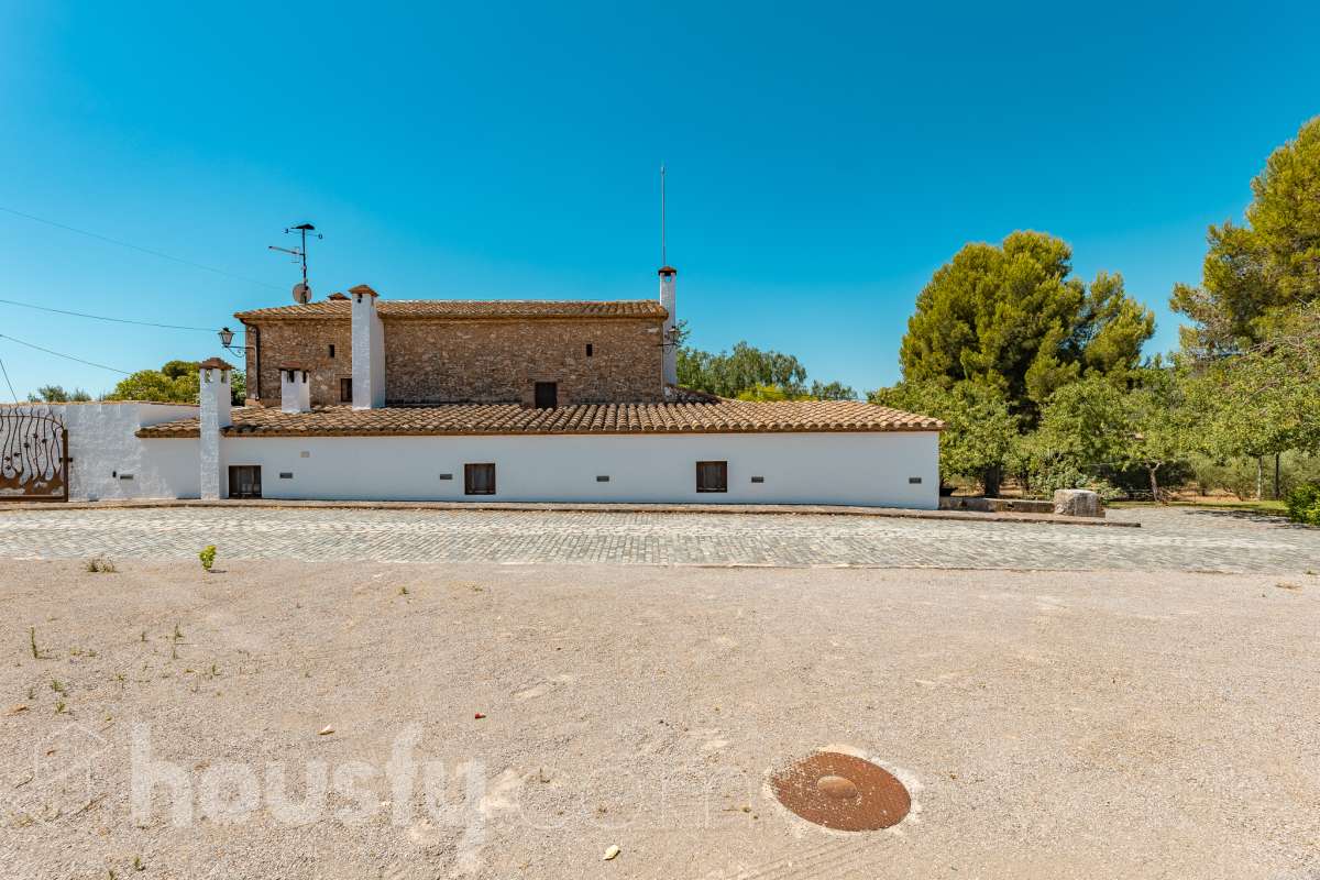 Housfy vende masía histórica de finales del S.XIX – El corazón del Penedès Descubra esta excepcional masía de piedra, un oasis de tranquilidad y autenticidad restaurado minuciosamente en 2010. Con una superficie construida de 351 m² sobre una extensa parcela de 8.502 m², esta propiedad combina a la perfección la tradición arquitectónica catalana con el máximo confort moderno. Lo que hace única a esta propiedad: Arquitectura y carácter: Restauración fiel que preserva elementos originales: vigas de madera de melis, techos de "volta catalana", suelos de mosaico antiguo y carpintería tradicional. Un viaje en el tiempo sin renunciar a las comodidades actuales. Entorno privilegiado: Ubicada en el corazón vinícola del Penedès, a tan solo 50 km de Barcelona y el aeropuerto, y a 20 km de Sitges. Disfrute de un entorno natural rodeado de viñedos, perfecto para actividades al aire libre como senderismo o rutas ecuestres. Zona exterior diseñada para disfrutar: Un espacio exterior con porches de columnas milenarias, piscina y una completa zona de barbacoa/horno de leña tradicional. Incluye una zona de sombra natural bajo moreras centenarias, huerto privado, frutales y un espacio polivalente de 3.700 m² apto para instalaciones hípicas. Sostenibilidad y equipamiento: La casa cuenta con sistema de calefacción geotérmica de alta eficiencia, pozos propios (caudal garantizado de 9.000 l/h), depuradora ecológica y conexión a fibra óptica, garantizando un funcionamiento autónomo y eficiente. Distribución y detalles: Amplios espacios interiores, incluyendo una biblioteca, cocina rústica de 28 m² con chimenea, gran salón de reuniones con capacidad para 24 comensales y bodega. La planta superior conserva el encanto original con acceso a un desván polivalente de 90 m². Esta propiedad es ideal para quienes buscan una residencia singular, un refugio de fin de semana o una oportunidad de inversión en una de las zonas más demandadas y con mayor encanto de Cataluña. Quiere visitarla? Contacte con Housfyy agende su visita sin compromiso. Más información en: housfy.com-53
