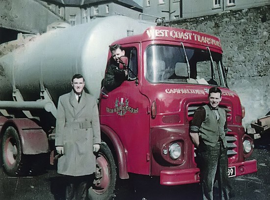 two young men standing in front of lorry
