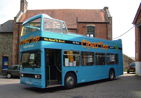 bright blue open top bus