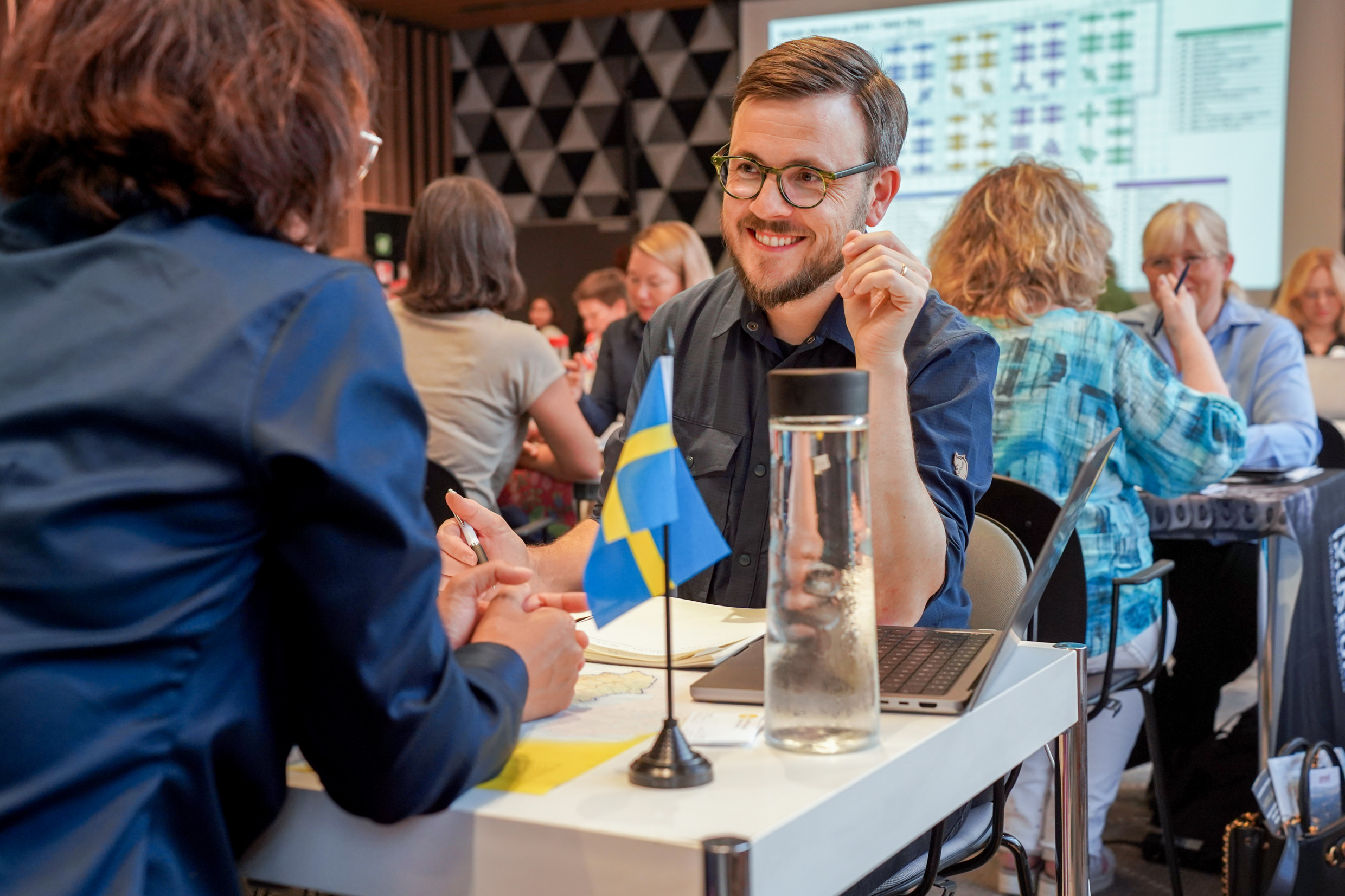 Två personer möts och pratar svenska resmål på en workshop.