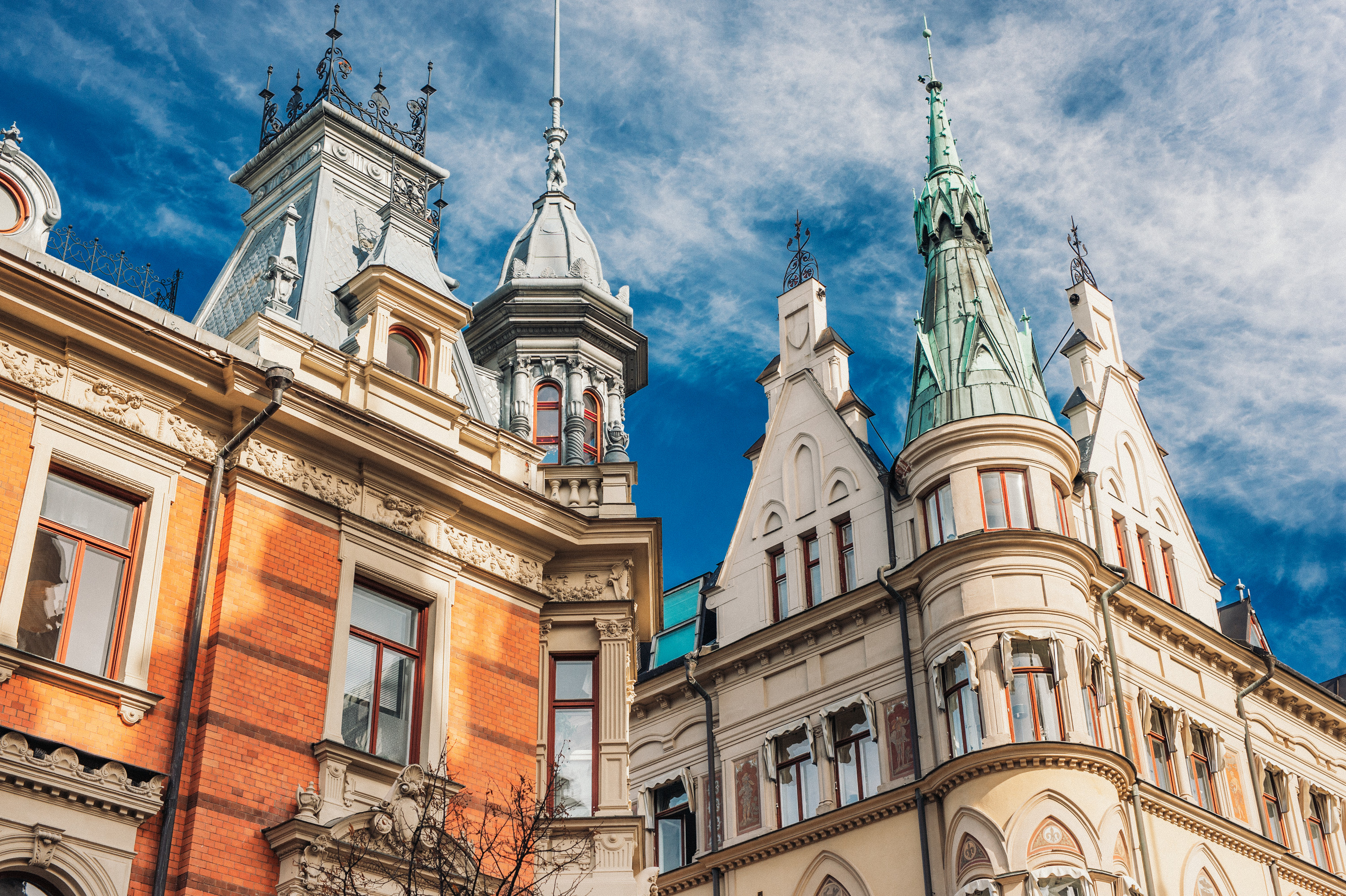 Övre delen av två höga hus av en äldre stil, himlen i bakgrunden.