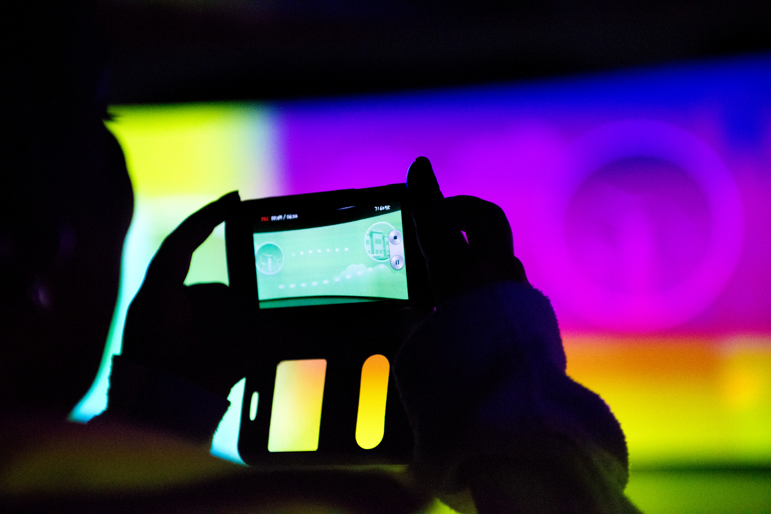 En som person fotograferar en stor digital bildvägg.