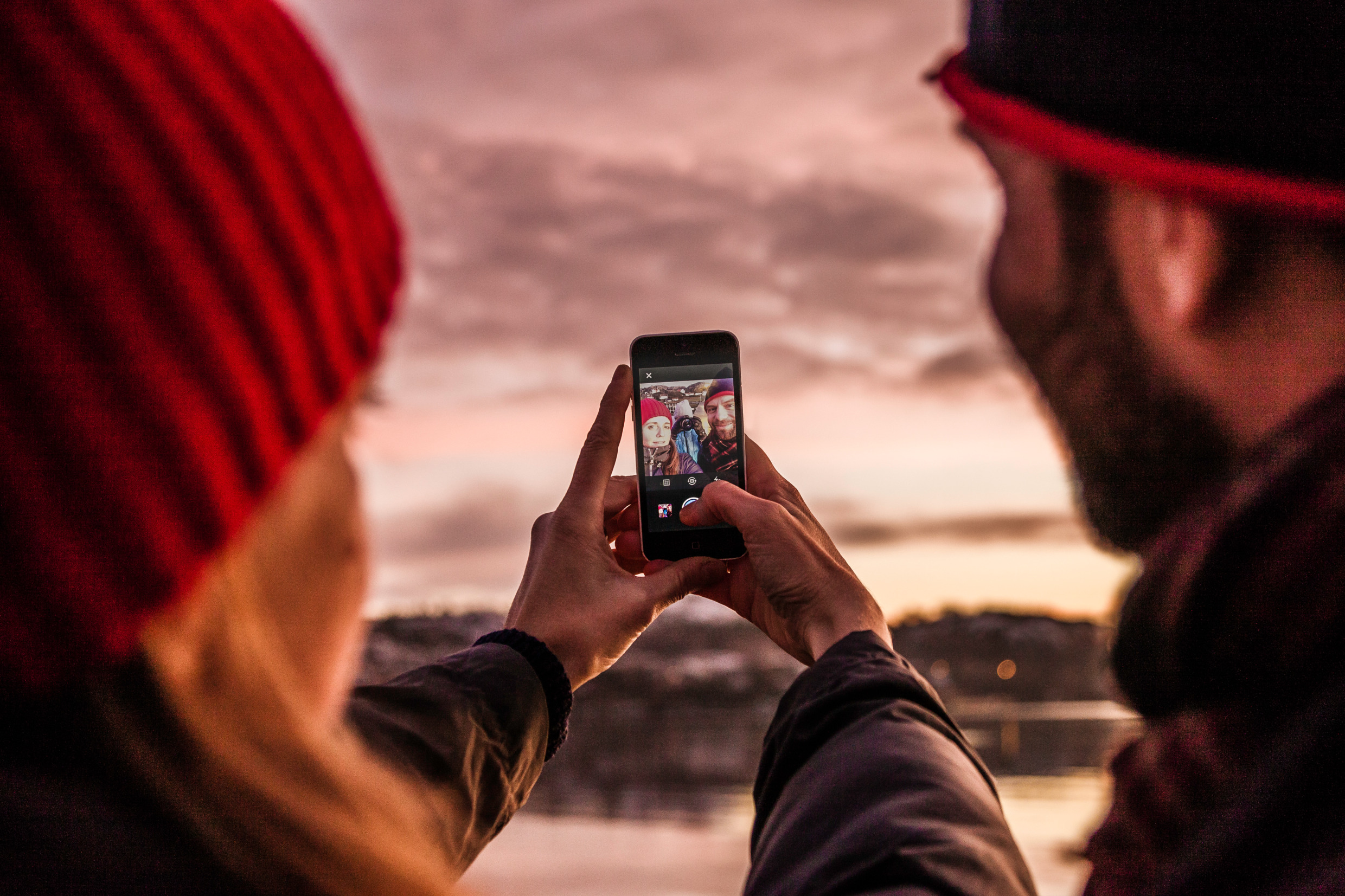 Två personer tar en solnedgångsbild någonstans i Sverige.