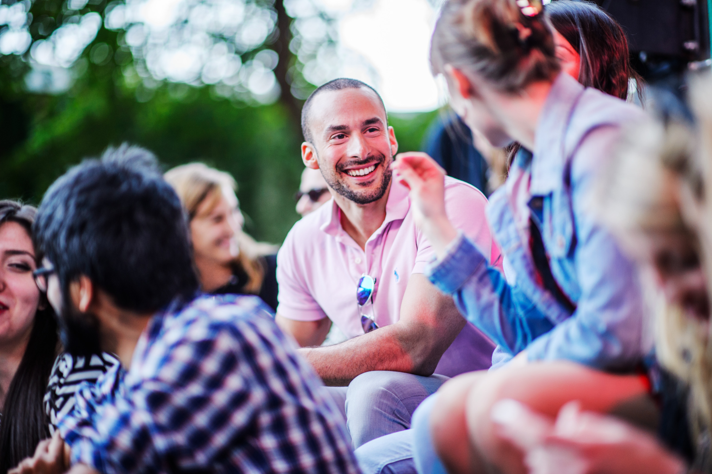 Flera personer sitter utomhus och diskuterar.
