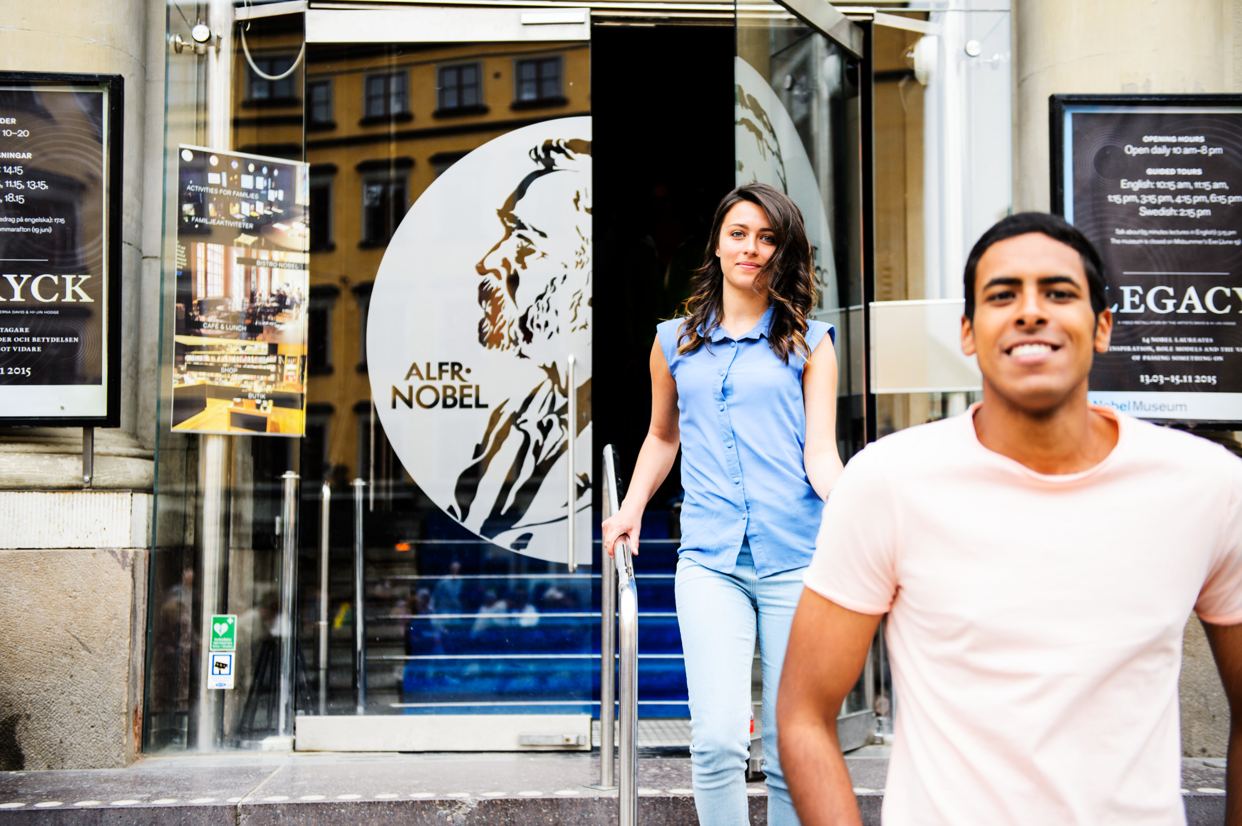 Två glada personer går ut från Nobelmuseet i Stockholm.