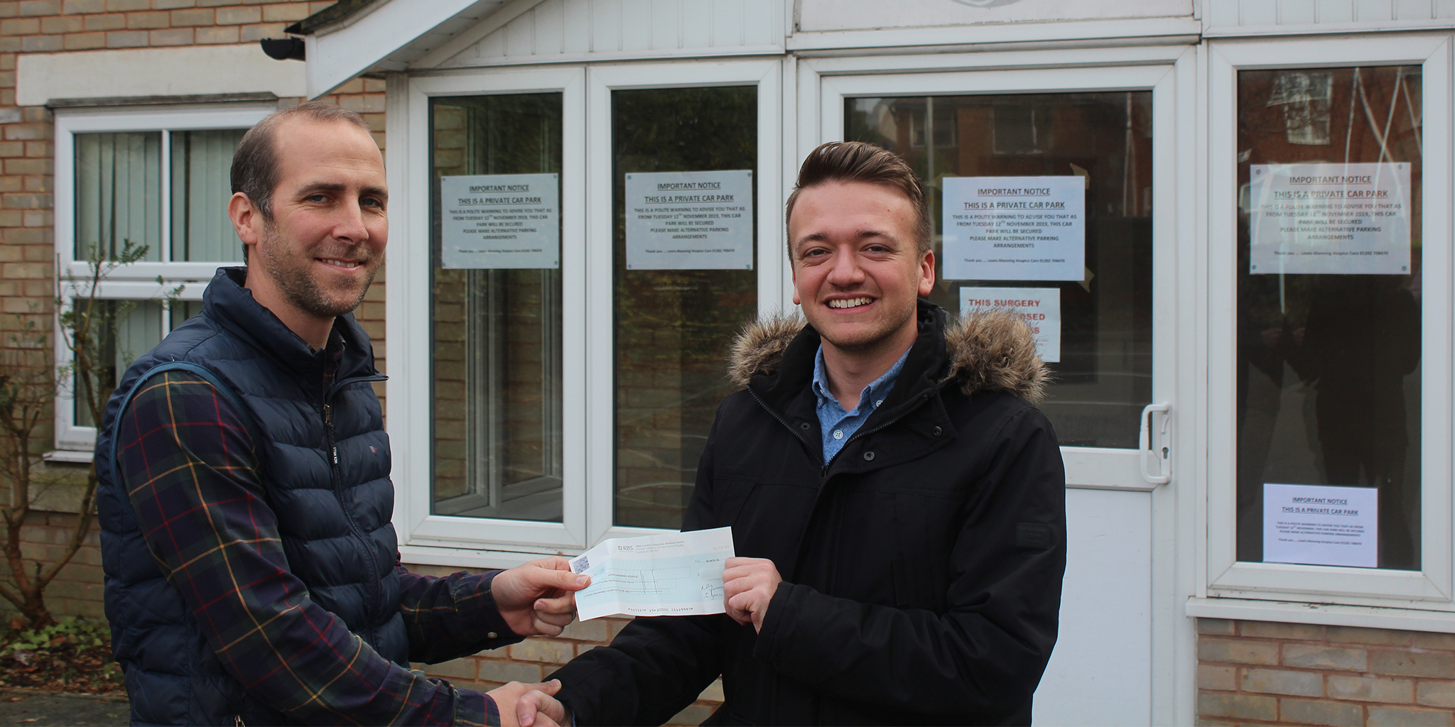 Photo of Tom Goodinge from Lewis-Manning Hospice receiving a cheque from morebus's Joe Quinlan