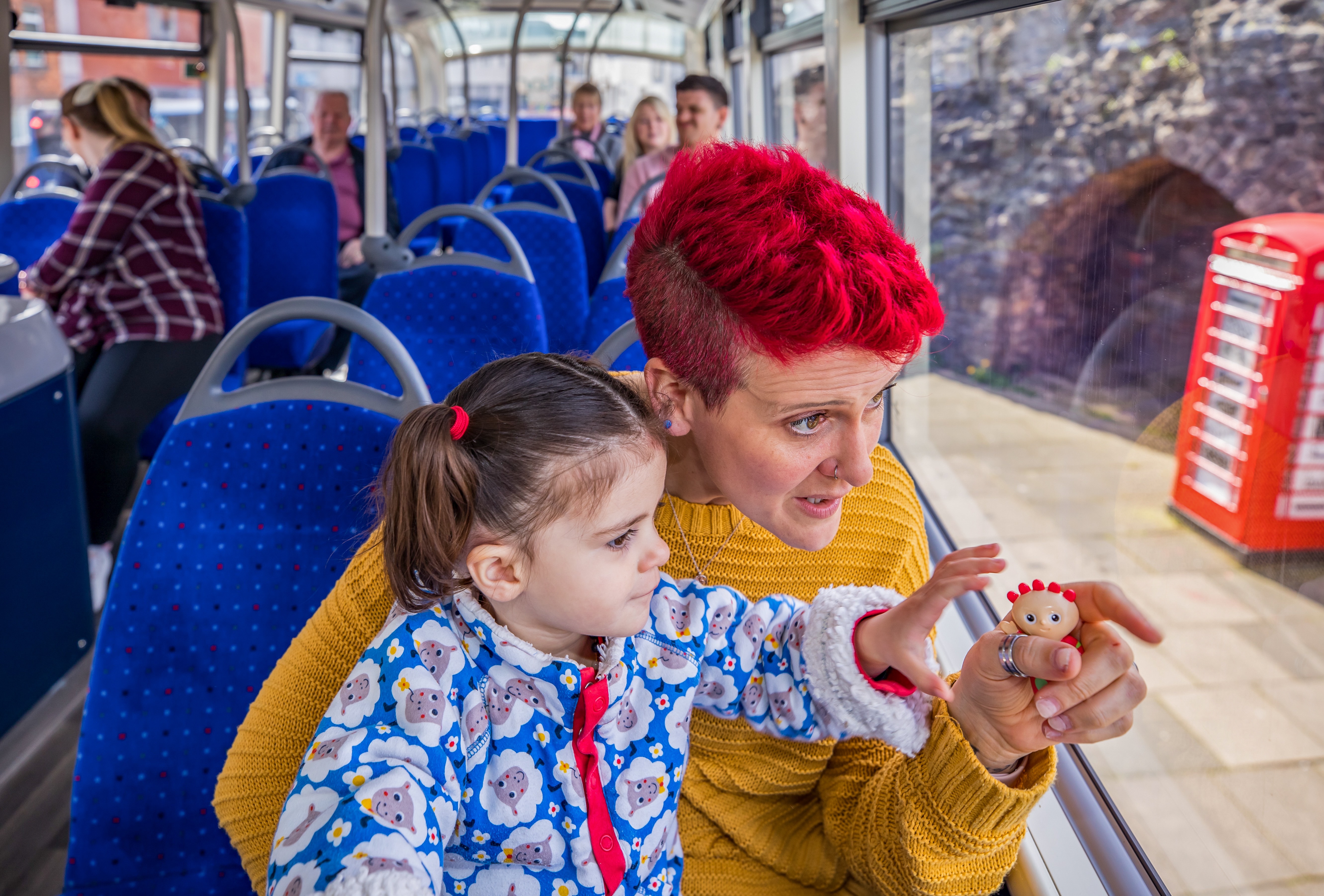 Mum and child on the bus pointing out the window