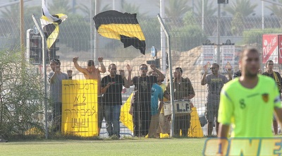 אוהדי בית&qout;ר עם שלט נוסף ברקע של הקפטן אבירם ברוכיאן (משה חרמון) אוהדי בית&qout;ר עם שלט נוסף ברקע של הקפטן אבירם ברוכיאן (משה חרמון)