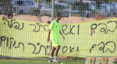 עמית בן שושן על רקע עוד אחד מהשלטים שתלו האוהדים (משה חרמון) עמית בן שושן על רקע עוד אחד מהשלטים שתלו האוהדים (משה חרמון)