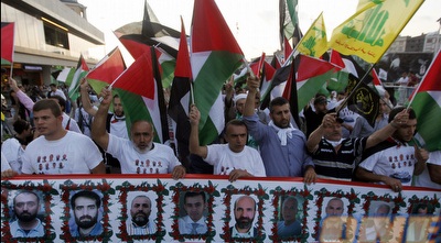 מפגינים פרו פלסטינים עם תמונות של הרוגי המרמרה לפני המשחק (רויטרס)