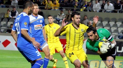 אוהד כהן עם הכדור ביד, קולאוטי מרים ידיים (משה חרמון) אוהד כהן עם הכדור ביד, קולאוטי מרים ידיים (משה חרמון)