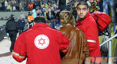 אוהדת מכבי מקבלת טיפול רפואי לאחר זריקת האבוקה (יניב גונן)