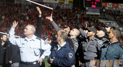 אנשי המשטרה חוטפים את המוטות ליד היציע (יוסי ציפקיס)