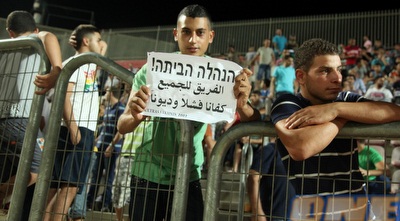 אחד מאוהדי סכנין עם שלט מחאה נגד ההנהלה (עמית מצפה)