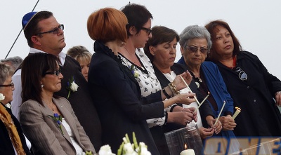 קרובי המשפחה של הנספים מדליקים נר לזכר קרוביהם (רויטרס)