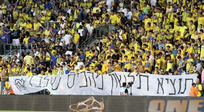 אוהדי מכבי ת&qout;א והשלט שנתן השראה (שי לוי)