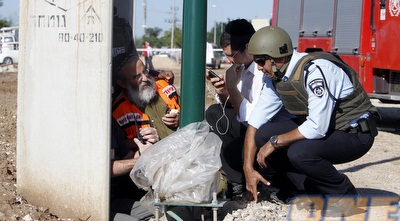ישראלים מסתתרים מאחורי קיר בטון (רויטרס)