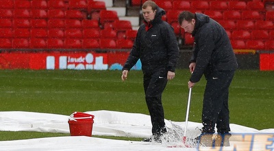 עובדי התחזוקה באולד טראפורד מנסים להילחם בגשם (רויטרס)