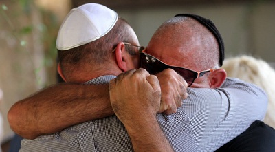 חזי שירזי ושינו זוארץ מתחבקים בלוויתו של ניצן שירזי (רדאד ג&acute;בארה)