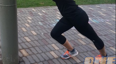 מתיחה לתאומים תוך כדי הישענות על עמוד