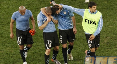 שחקני אורוגוואי מנסים להתנחם לאחר ההפסד (רויטרס)