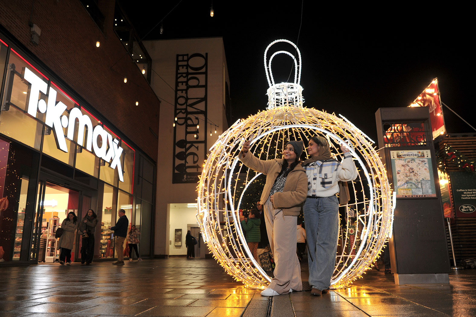 Christmas walk-through bauble with two young women taking a selfie inside outside shops