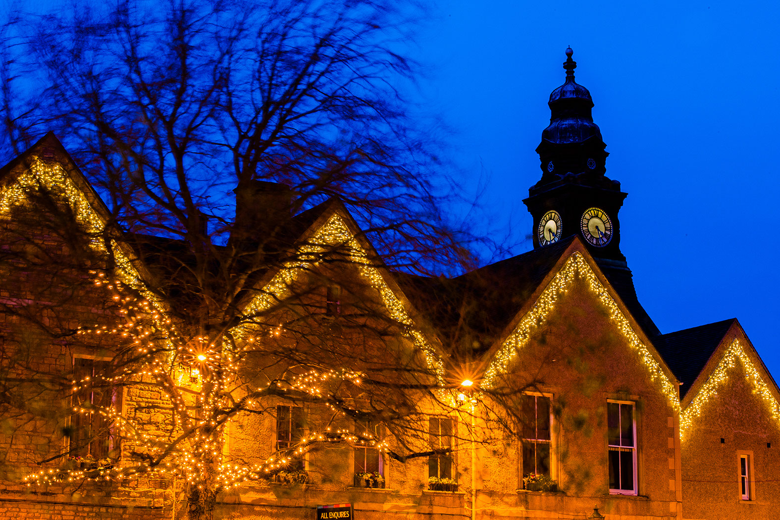 Warm white icicle lights on the eaves of a historic building