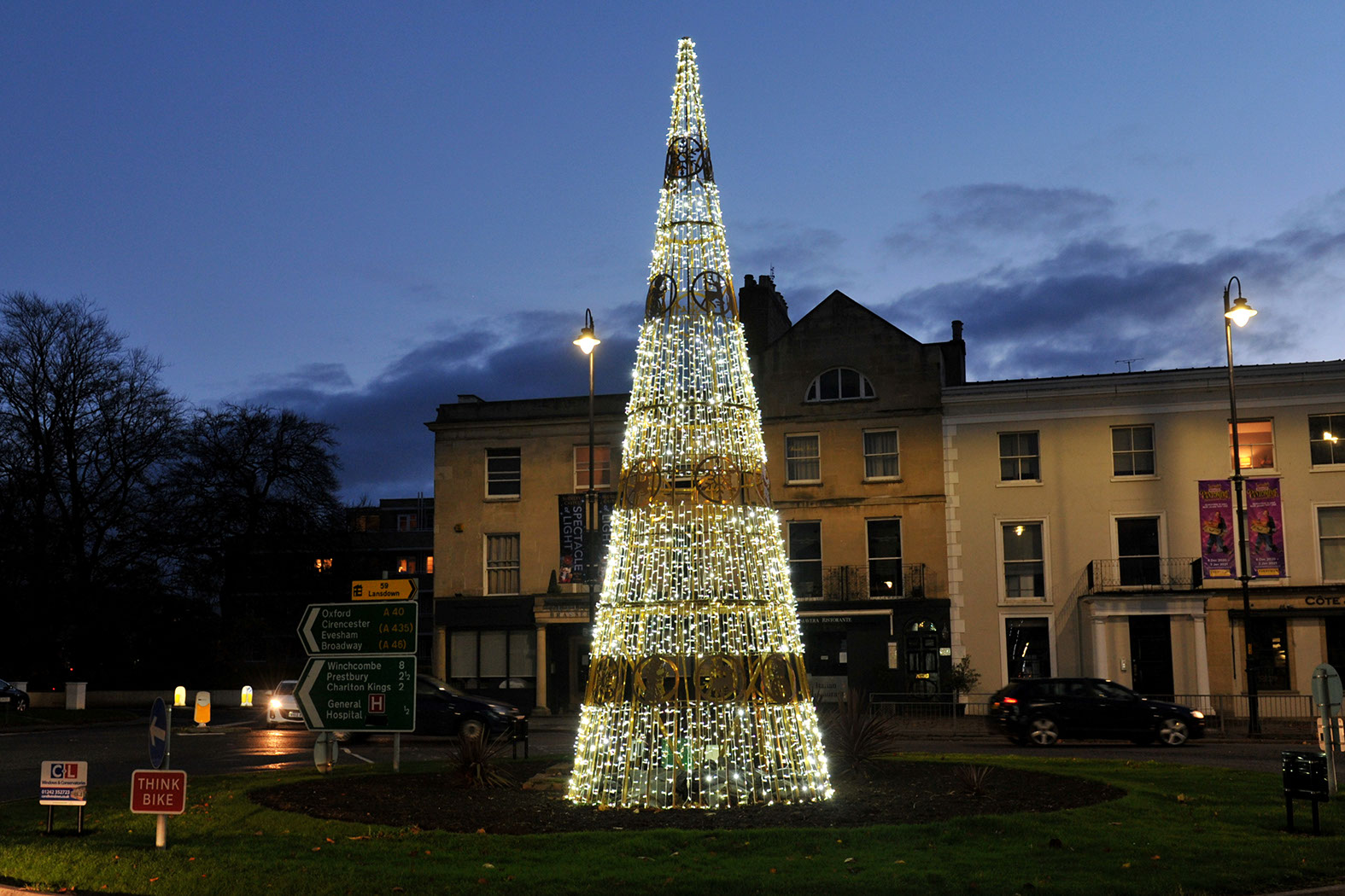 White light-string cone tree decorated with bands of gold ornaments