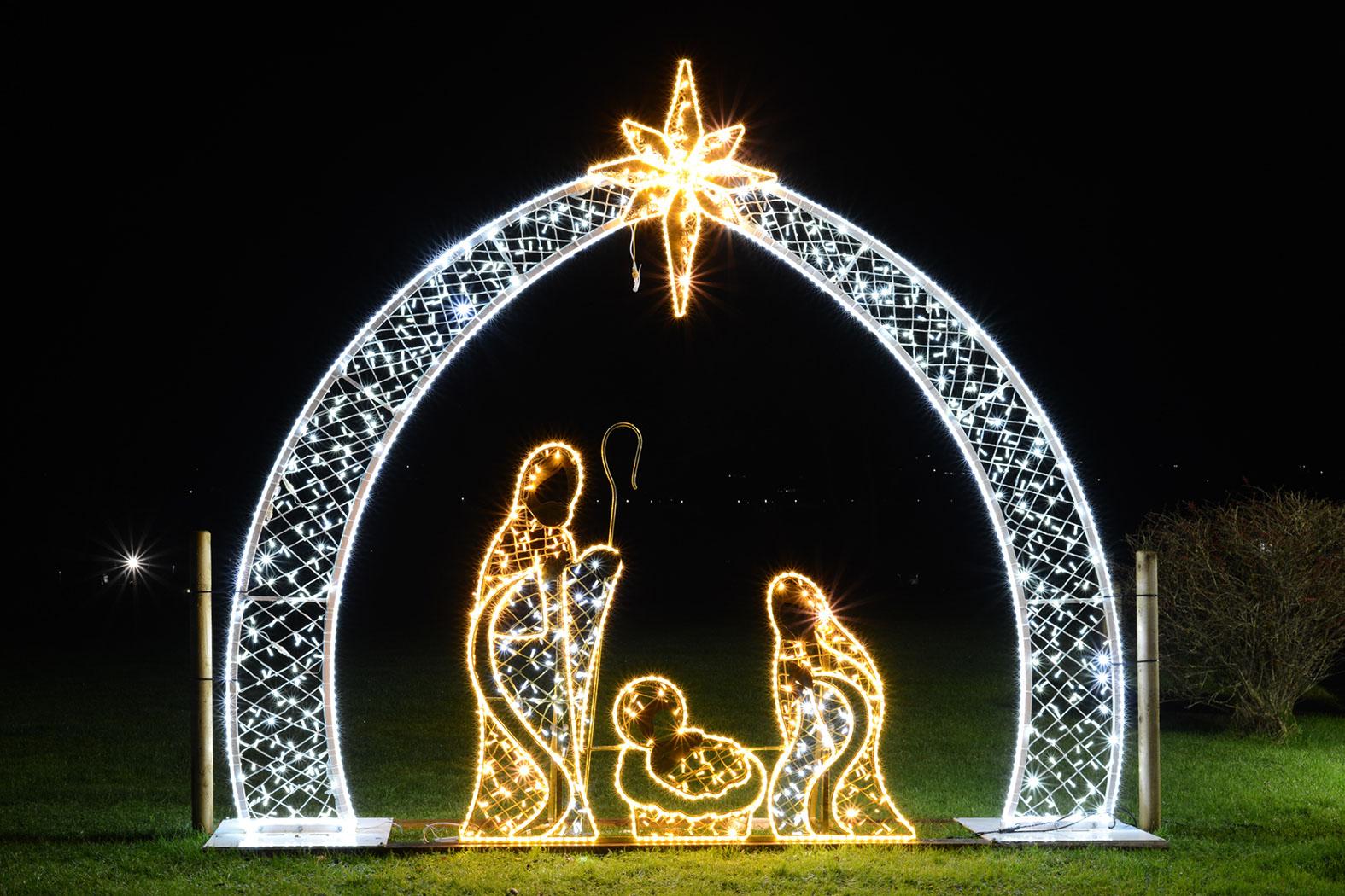 Illuminated nativity scene featuring Mary, Joseph, and Jesus under an arch
