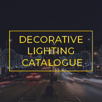 Commercial light strings wrapped around trees along a busy avenue