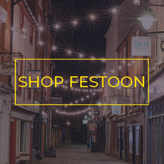 Commercial festoon lights spanning a quaint shopping street