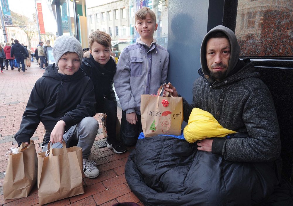 Reading children help the homeless with Christmas parcels