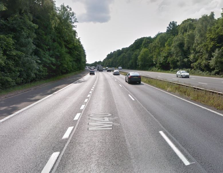 Woman dies after car crashes into woodland on M40