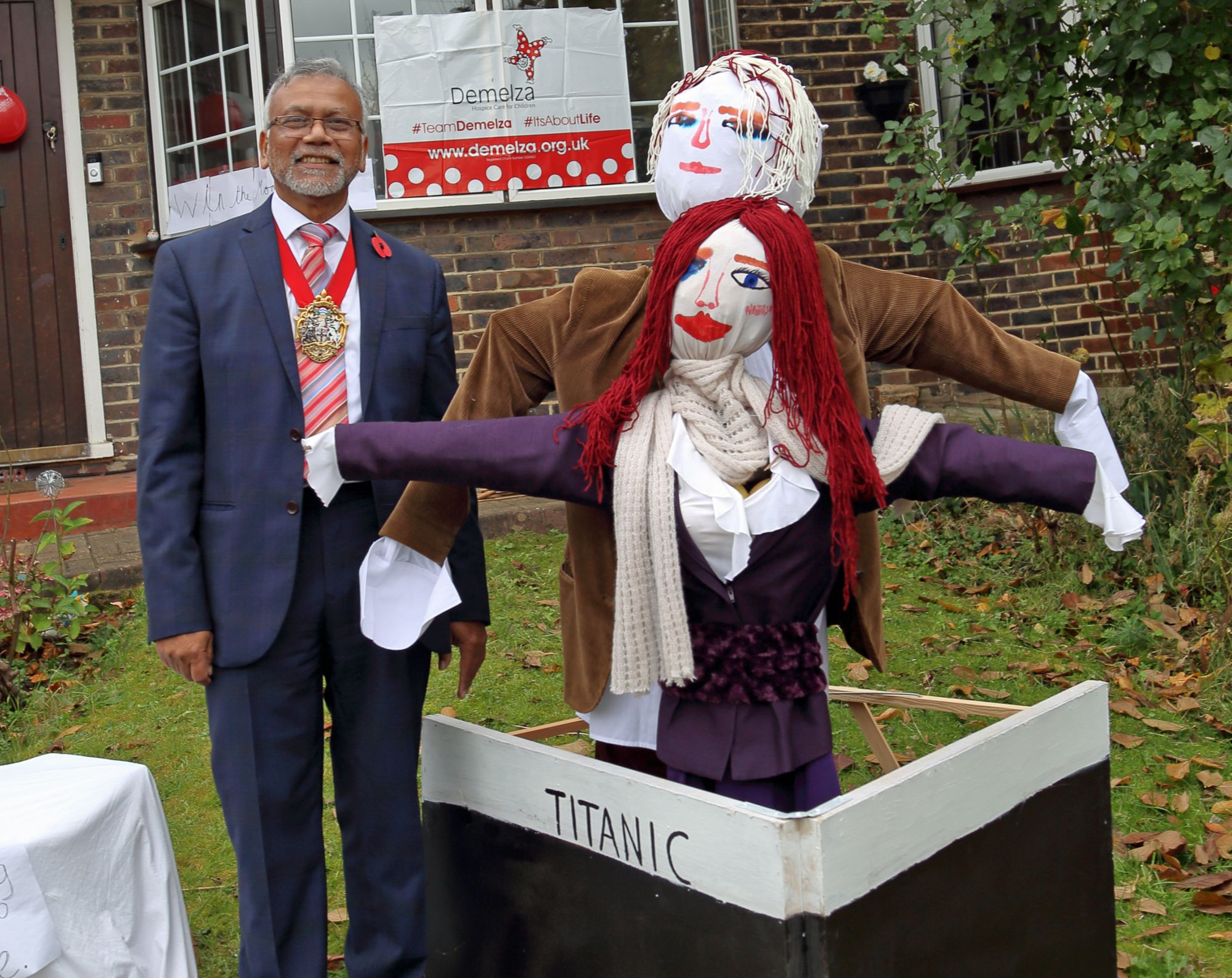 The Mayor of Croydon standing next to a pair of scarecrows on the Titanic.