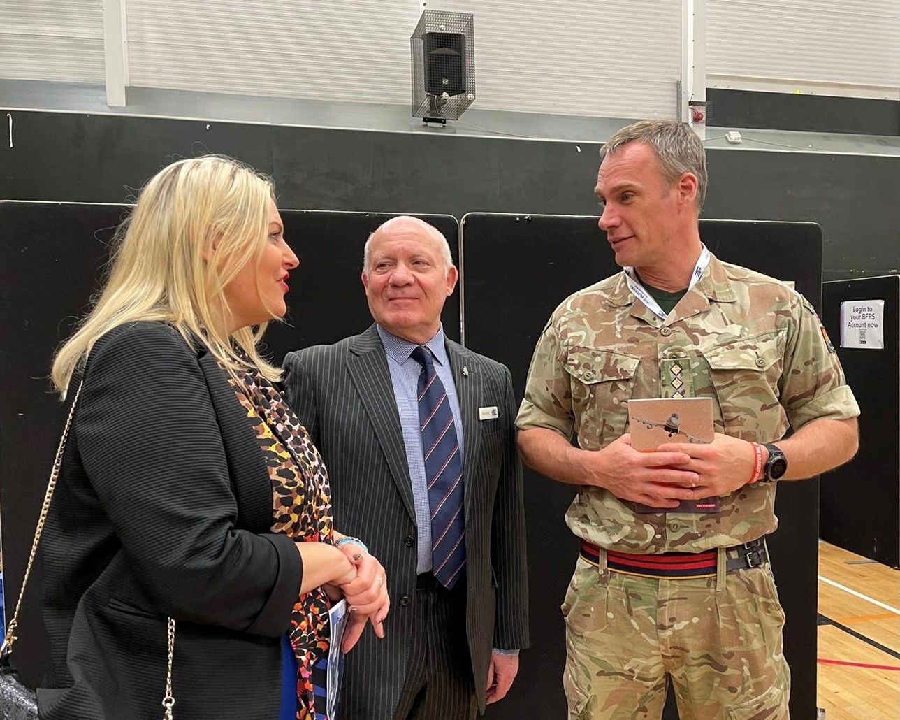Mims Davies MP standing next to a soldier in military uniform, and a man wearing a suit
