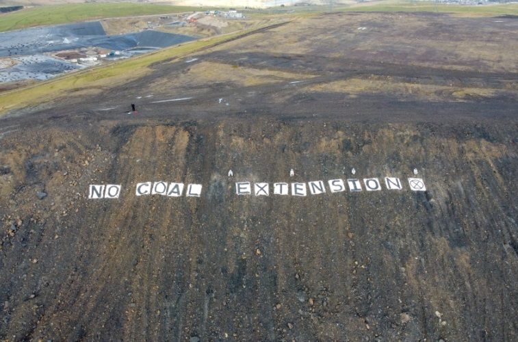 Extinction Rebellion protestors display banner at Ffos-y-frân opencast mine in Merthyr Tydfil