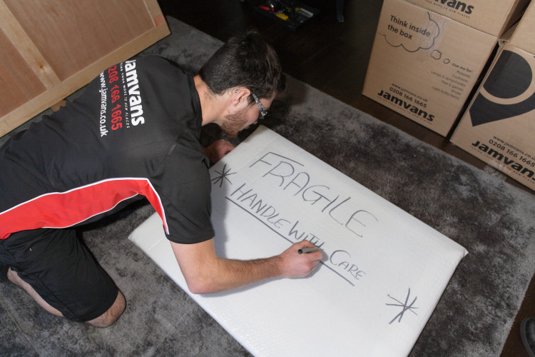 Man writing fragile sign