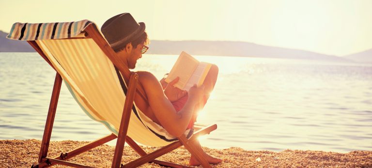 GS Man reading book on beach 491406822 getty RGB 136 DPI For Web