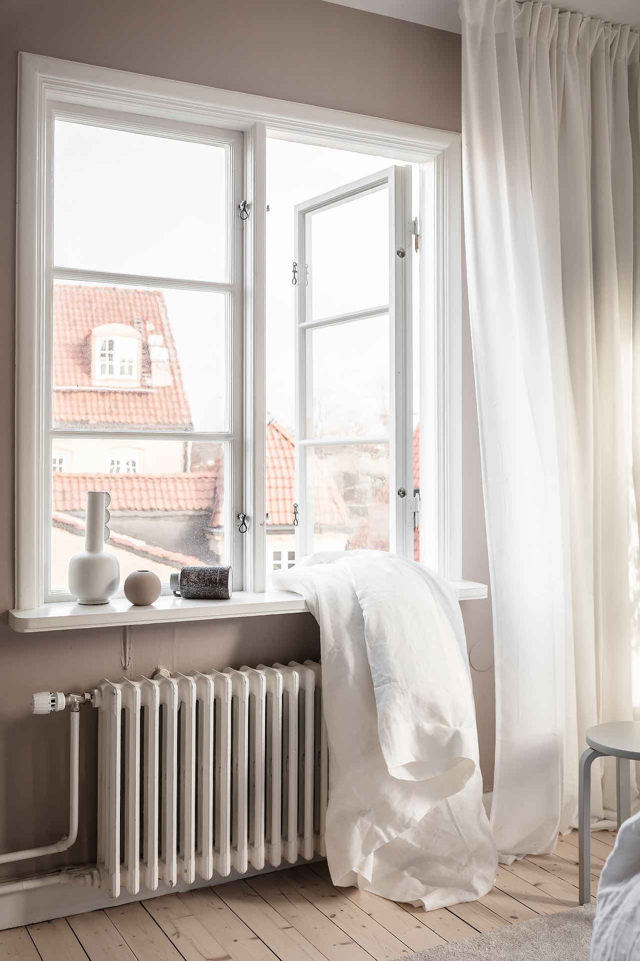 Ljust sovrum med gardiner på gardinskena
