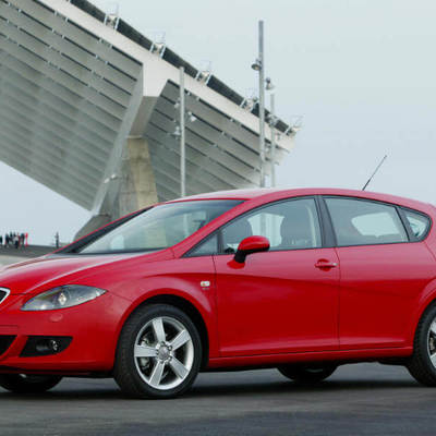 Un coche rojo está aparcado en la calle