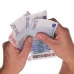 Dos manos sujetan varios billetes