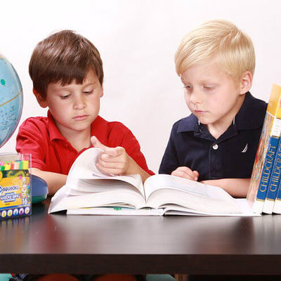 Dos niños están pasando páginas por un libro