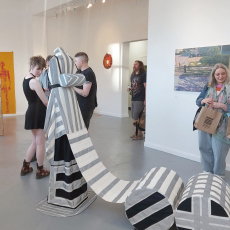 Gallery with art on walls and sculpture in the center of the room