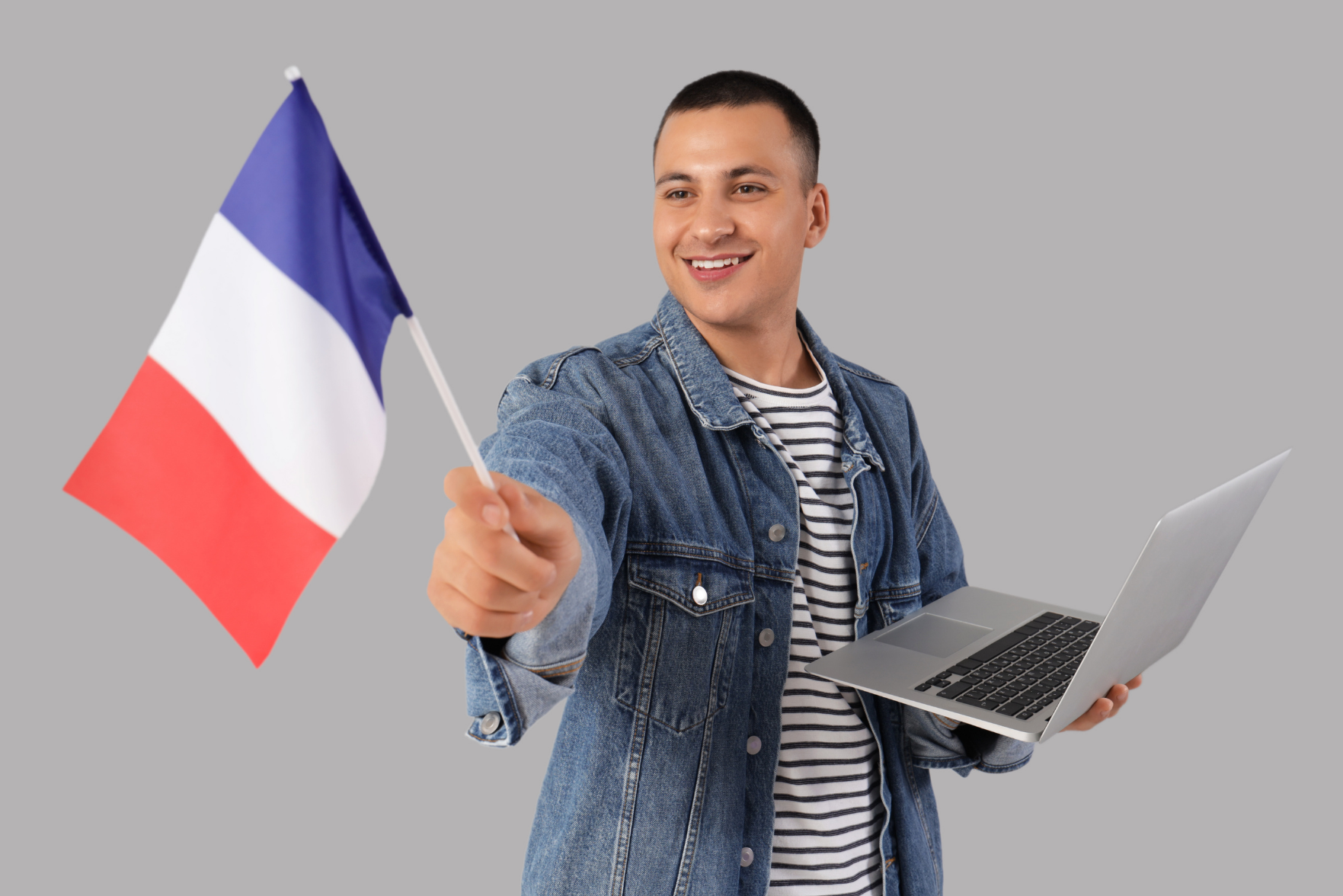 A man holding a laptop and waving French flag