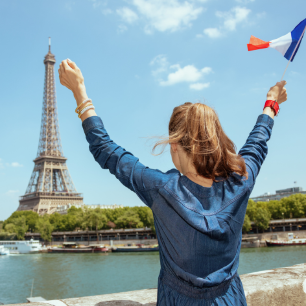 Girl waving a French flag at the Eiffel Tower