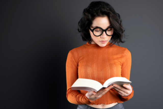 Woman in an orange top reading a book