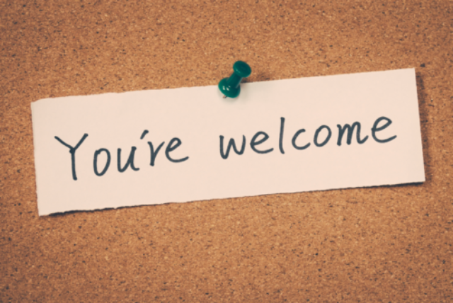 A note reading 'You're welcome' pinned on a cork board