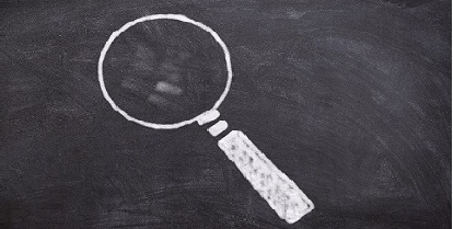 drawing of a magnifying glass on a blackboard