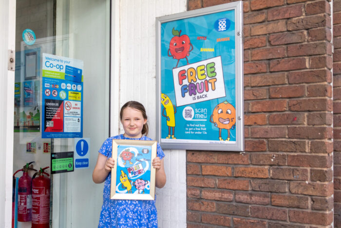Ten-year-old’s artwork advertises free fruit scheme in 100 local shops image Image of Olivia-with-artwork.jpg for Ten-year-old’s artwork advertises free fruit scheme in 100 local shops